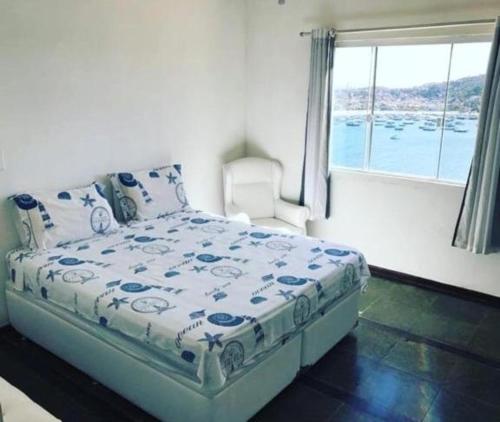 a bedroom with a bed in a room with a window at Pousada Recanto Marinho in Arraial do Cabo