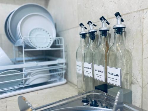 a group of glass bottles sitting on top of a sink at Teo’s Spacious and Affordable Home in Cabanatuan in Cabanatuan