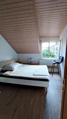 una camera con un grande letto e un soffitto in legno di Duplex avec vue lac et montagnes a Montreux