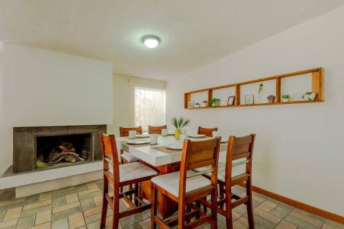 a dining room with a table and chairs and a fireplace at Casa Boho. Hermosa casa equipada céntrica in Chihuahua