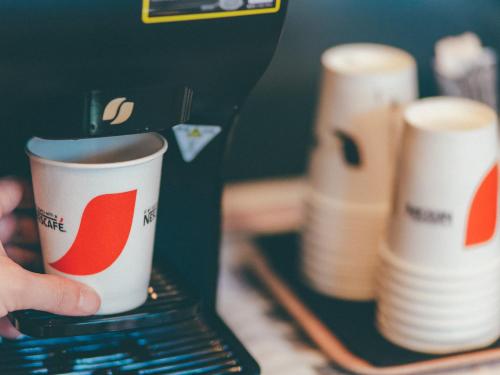 a person is holding a coffee cup on a laptop at Hamilton Hotel Red in Nagoya