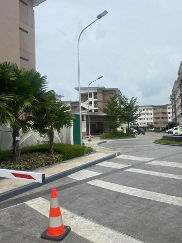 an empty parking lot with a traffic cone in the street at Twenty-Nine Cats - SMDC Cheer Residences Marilao in Marilao