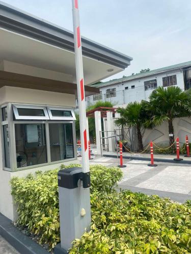 a pole in front of a building with some bushes at Twenty-Nine Cats - SMDC Cheer Residences Marilao in Marilao