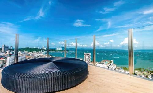 un gran otomano negro en un balcón con vistas al océano en BASE Central PATTAYA Quiet Room with Infinity Pool & Free Netflix en Pattaya Central