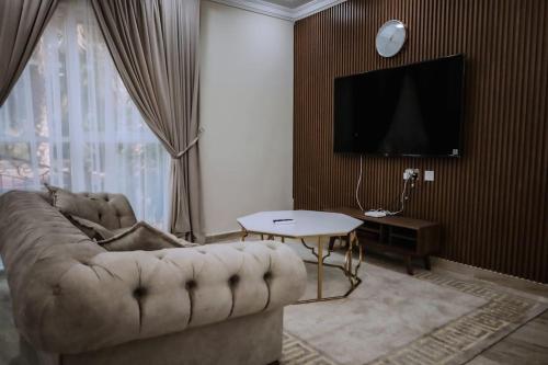 a living room with a couch and a tv at Hatta Orchard in Hatta