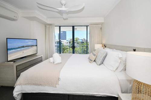 a bedroom with a large bed and a television at Alexandra Headland Resort Heaven, Pool / Beach ZD8 in Alexandra Headland
