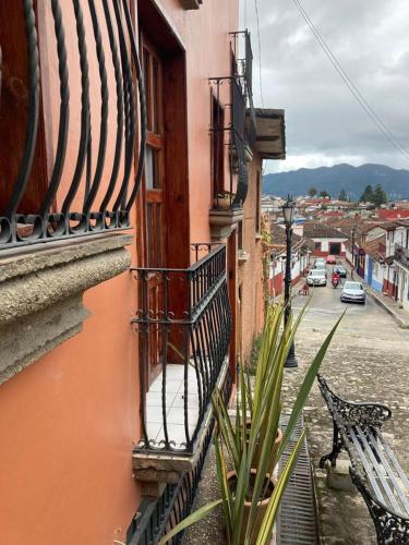 a balcony of a building with a bench on a street at DEPARTAMENTO EN SAN CRISTOBAL Centro ESTACIONAMIENTO LUGARES PUBLICOS EN LA CALLE in San Cristóbal de Las Casas