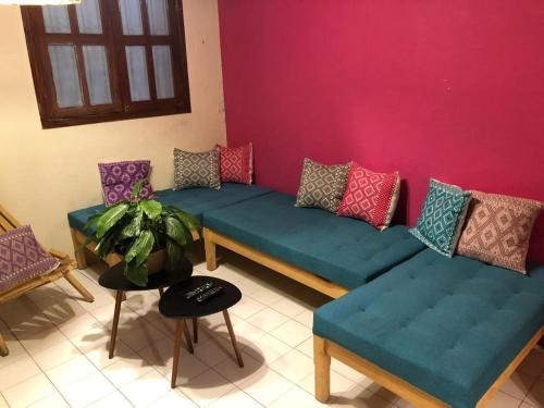 a living room with couches and a pink wall at DEPARTAMENTO EN SAN CRISTOBAL Centro ESTACIONAMIENTO LUGARES PUBLICOS EN LA CALLE in San Cristóbal de Las Casas