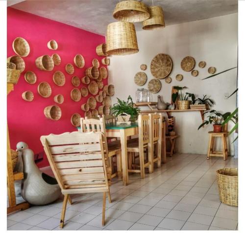a dining room with a table and a pink wall at DEPARTAMENTO EN SAN CRISTOBAL Centro ESTACIONAMIENTO LUGARES PUBLICOS EN LA CALLE in San Cristóbal de Las Casas