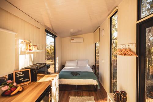 a bedroom with a bed in a tiny house at Ridgeway Retreat in Queanbeyan