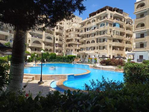 a swimming pool in front of a large apartment building at Chalet At Wahet Al Nakhil resort in Alexandria