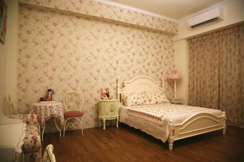 ein Schlafzimmer mit einem Bett und einem Tisch und Stühlen in der Unterkunft RUBATO B&B in Hualien