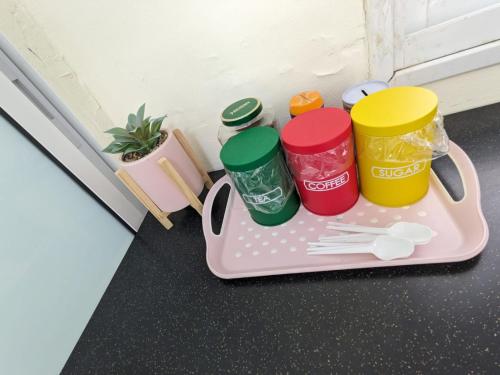 un vassoio con quattro tazze e utensili di colore diversi di חדר אירוח צפתי לזוג a Safed