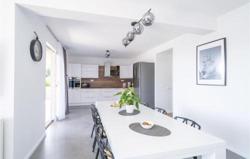 a kitchen and dining room with a white table and chairs at Nice Apartment In Molunat With Wifi in Molunat