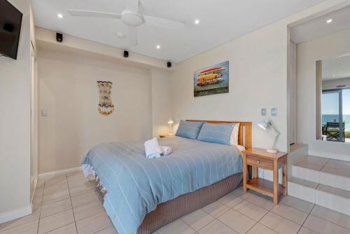 a bedroom with a bed and a table and a window at Aqua Shores Studio in Mollymook