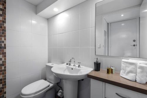 a white bathroom with a toilet and a sink at Aqua Shores Studio in Mollymook