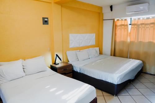 duas camas num quarto com duas camas sidx sidx em HOTEL ROBLE ZIHUATANEJO em Zihuatanejo