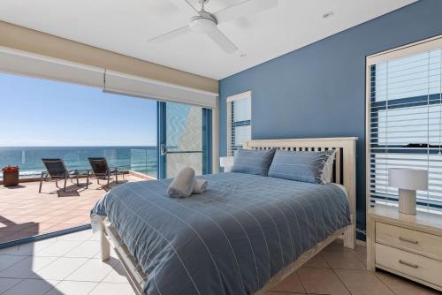 a bedroom with a bed and a large window at Aqua Shores Penthouse in Mollymook