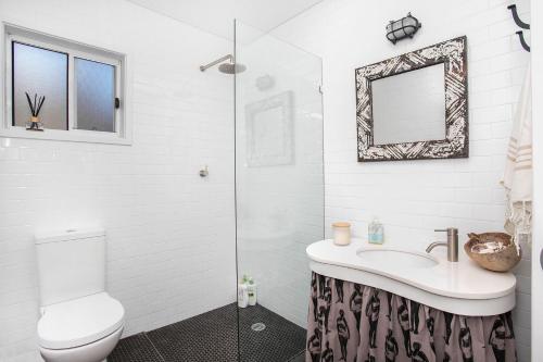 a bathroom with a toilet and a sink and a mirror at Daybreak Mollymook in Mollymook