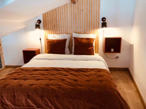 紹維尼的住宿－Gites De la Cour au Grenier，一间卧室配有一张大床、两盏灯和一台电视。