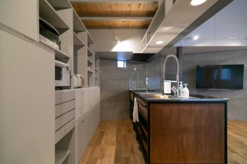a kitchen with a sink and a counter top at Social Guest House neltoko in Nanao