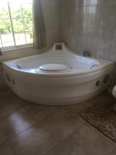a white bath tub in a bathroom with a window at Retreat Guest House in Falmouth