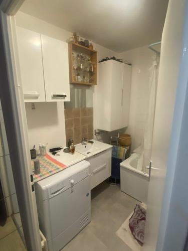 une petite cuisine avec un évier et une baignoire dans l'établissement Chambre dans une résidence très calme, à Nanterre