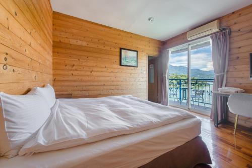 a bedroom with a bed with a wooden wall at Bishui Shanju Lakeside B&B in Yuchi