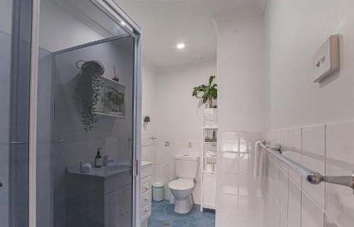 ein weißes Bad mit einem WC und einer Dusche in der Unterkunft Winya Girragirra Lake House in Yatte Yattah
