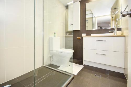ein Bad mit einem WC und einer Glasdusche in der Unterkunft Maroochydore Stylish Luxury - Pool / Beach ZD9 in Maroochydore