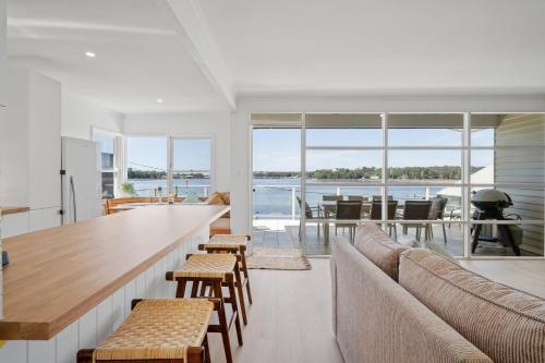 a living room with a bar and a view of the water at Burrill Lake Cottage in Burrill Lake