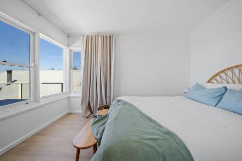 a bedroom with a bed and a large window at Burrill Lake Cottage in Burrill Lake