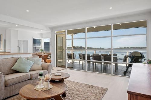 a living room with a couch and a table at Burrill Lake Cottage in Burrill Lake