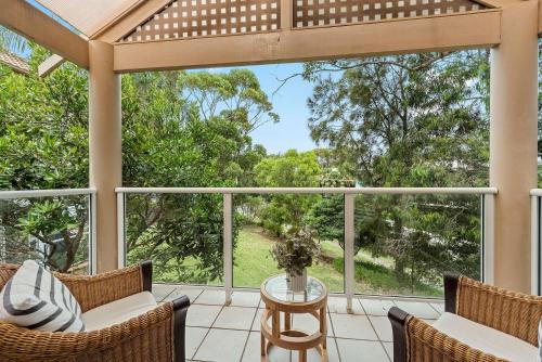 a screened in porch with chairs and a table at Sandy Days in Mollymook Beach in Mollymook