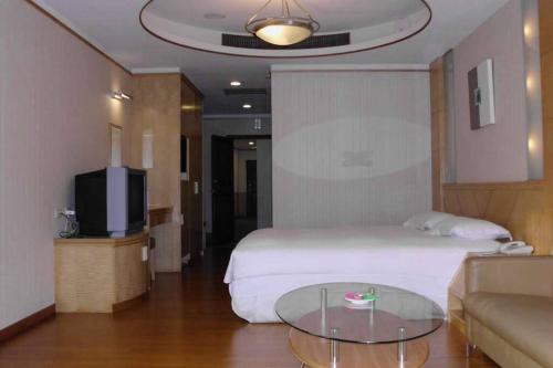 a hotel room with a bed and a glass table at Jia Yun Business Hotel in Yongkang
