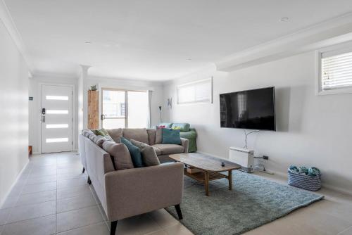 a living room with a couch and a table at Foredeck Views at Manyana in Manyana
