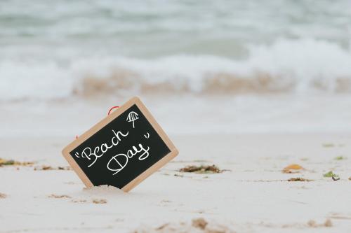 a sign in the sand on a beach at Ocean Sands Beach Boutique Inn-1 Acre Private Beach-St Augustine Historic-2 Miles-Shuttle with Downtown Tour-HEATED Salt Water Pool until 420AM-Popcorn-Cookies-New 4k USD Black Beds- 69 Item Breakfast-Eggs-Bacon-Starbucks- Free Laundry- #904-799-SAND in Saint Augustine