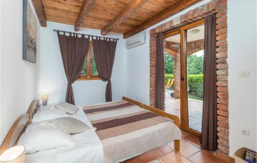 a bedroom with a bed and a large window at Lovely Home In Dolinci With Outdoor Swimming Pool in Grižane