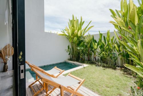 eine Terrasse mit Swimmingpool und Liegestuhl in der Unterkunft Canggu 2Plex Apartment in Canggu
