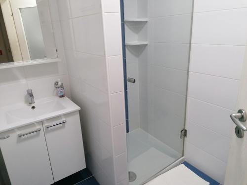 una ducha con una puerta de cristal junto a un lavabo en APARTMAN 1 en Baška
