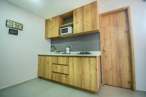 a kitchen with wooden cabinets and a door at Barcelo Coliving in Medellín