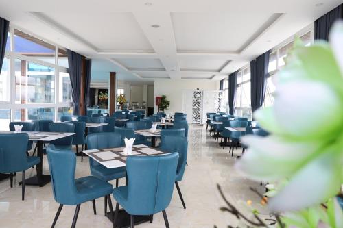 a dining room with tables and blue chairs at Le Marais Hotel Dalat in Da Lat