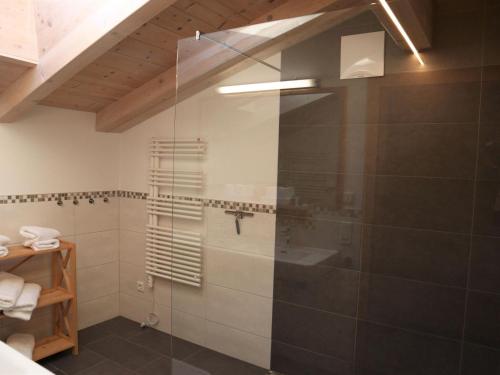 La salle de bains est pourvue d'une douche avec une porte en verre. dans l'établissement Apartment Rohregger, Neukirchen, à Neukirchen am Großvenediger