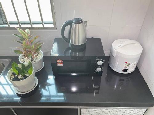 a counter top with a coffee maker and plants on it at JJ&KK Homestay in Simpang
