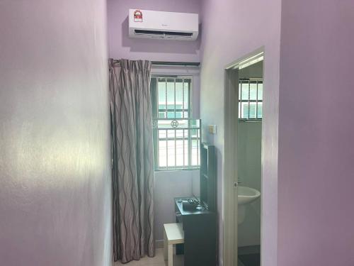 a bathroom with purple walls and a window and a sink at JJ&KK Homestay in Simpang