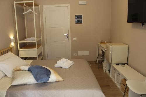 a small room with a bed and a desk and a sink at Aurora BnB in Pisa