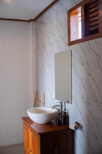 a bathroom with a bowl sink and a mirror at Backyard Canggu in Canggu