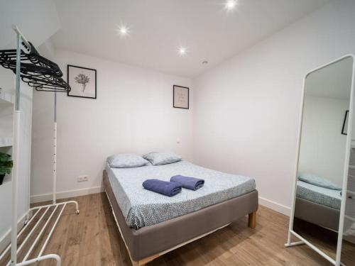 a bedroom with a bed with two blue pillows on it at Appartement tout équipé au coeur du Panier Vieux Port in Marseille