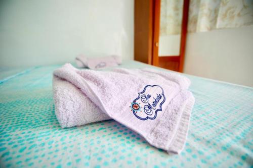 a towel sitting on top of a bed at Barco Seu Meschede in Santarém