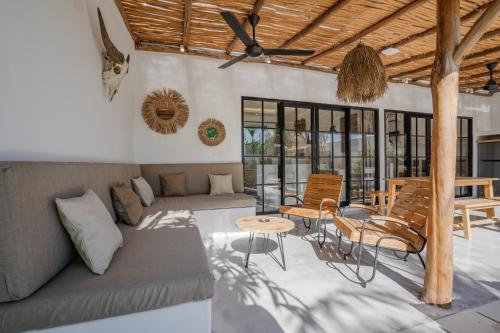 a living room with a couch and a table and chairs at Villa Ruta II - Luxury 2BR tropical villa next to Luna BC and Nyanyi beach in Tanah Lot